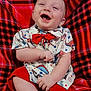 baby, child, smiling, laughing, red_bow_tie, shirt, shorts, plaid_blanket, feet, happy, cute, indoor, sitting, infant, person, clothing, joyful, portrait, expression, casual