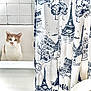cat, bathtub, shower_curtain, bathroom, tile_wall, indoor, pet, curious, white, beige, eiffel_tower_pattern, fabric, window_light, clean, domestic, animal, portrait, sitting, looking, cute