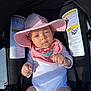 Eira joined the competition — help win amazing prizes! baby, car_seat, pink_hat, bib, flower, sunlight, infant, clothing, child, seat, safety_labels, portrait, cute, outdoor, hat, person, young_child, expression, hands, white_onesie