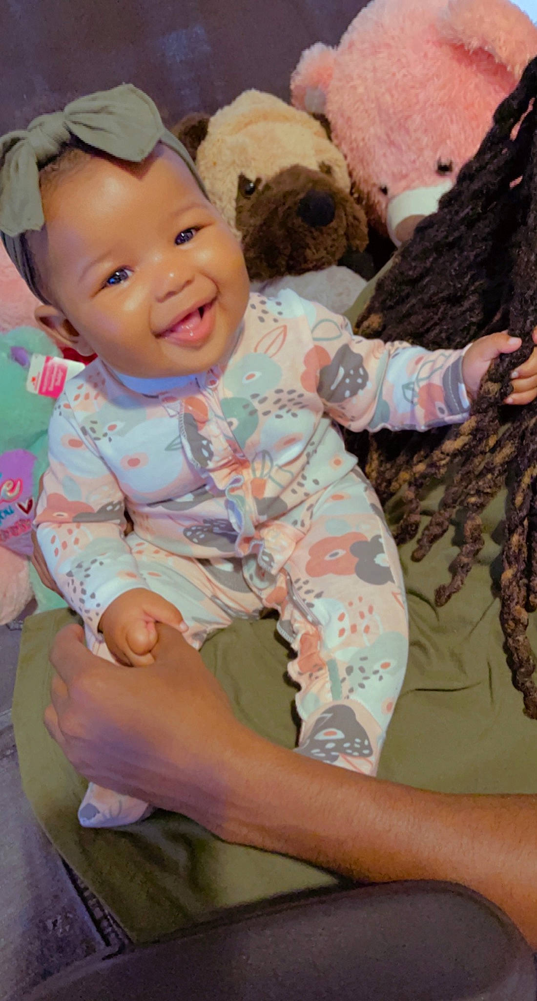 Gianna is registered to the contest to win money with this photo: arm, baby, baby_toddler_clothing, cheek, child, eye, finger, gesture, grass, happy, human_body, joy, military_camouflage, organ, person, pink, skin, sleeve, smile, textile