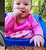 Jada is registered to the contest to win money with this photo: arm, baby, baby_toddler_clothing, child, facial_expression, finger, fun, grass, happy, head, headwear, leisure, mouth, nose, person, pink, plant, smile, snapshot, swing