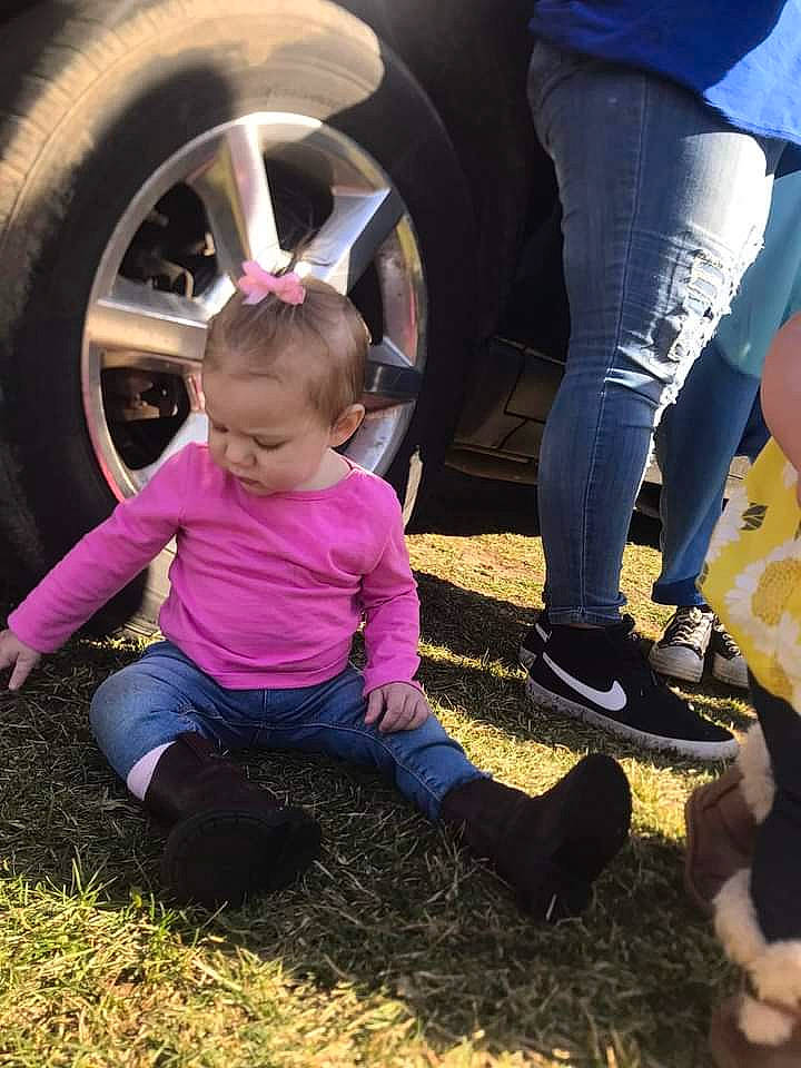 Jada is registered to the contest to win money with this photo: alloy_wheel, automotive_exterior, automotive_tire, beauty, bumper, fender, fun, grass, hubcap, motor_vehicle, people_in_nature, person, rim, shoe, sneakers, thigh, tints_and_shades, tire, toddler, vehicle_door