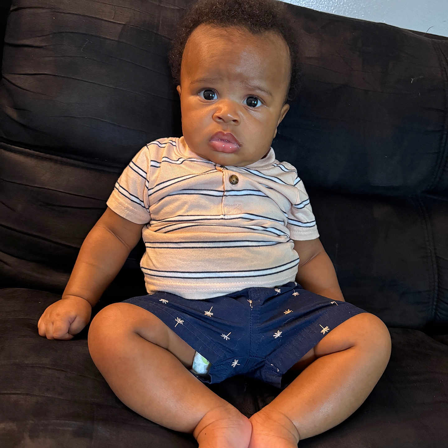 Tonna is registered to the contest to win money with this photo: baby, barefoot, child, clothing, couch, cute, expression, face, furniture, hair, indoor, infant, legs, person, portrait, shorts, sitting, skin, striped_shirt, young