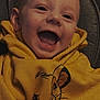 Ezio a rejoint le concours — aidez-le/la à gagner de superbes lots ! baby, child, smiling, hoodie, yellow, cartoon, lion, face, happy, cute, infant, clothing, portrait, sitting, expression, young, indoors, person, closeup, apparel