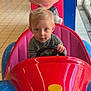 toddler, child, mickey_mouse, arcade, kiddie_ride, colorful, toy_car, steering_wheel, indoor, mall, floor_tiles, blond_hair, blue_eyes, plastic, amusement, playful, cute, portrait, entertainment, fun