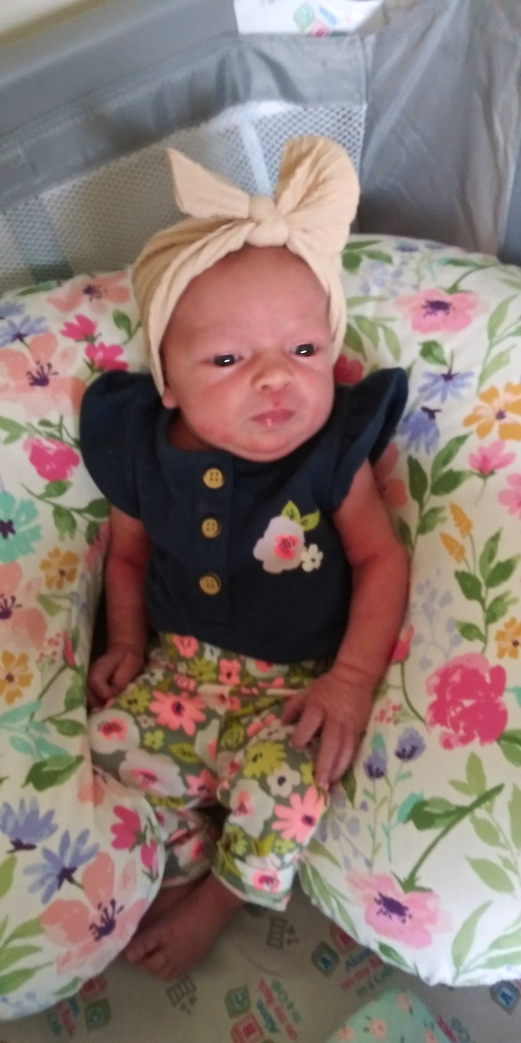 Ellyanna is registered to the contest to win money with this photo: arm, baby, baby_products, baby_toddler_clothing, cheek, comfort, eye, face, grass, head, human_body, iris, linens, pattern, person, pink, sitting, skin, sleeve, t_shirt