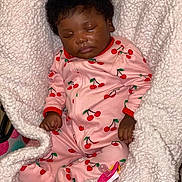 Sarya is registered to the contest to win money with this photo: baby, infant, sleeping, portrait, pink_outfit, cherry_pattern, onesie, blanket, white_blanket, pacifier, curly_hair, dark_skin, closed_eyes, peaceful, indoors, cozy, nursery, lying_down, child, photography