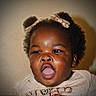 Ava is registered to the contest to win money with this photo: baby, child, curly_hair, hair_bow, expression, mouth_open, cute, adorable, infant, portrait, closeup, clothing, gold, smile, face, skin, young_child, indoors, person, happy