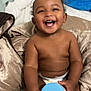 baby, smiling, diaper, blanket, bed, container, blue_lid, happy, child, indoors, skin, hand, sitting, cute, toddler, plush, head, face, room, comfort