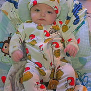 Marley joined the competition — help win amazing prizes! baby, infant, onesie, hat, grinch, baby_chair, blanket, indoor, person, clothing, cute, child, seated, soft_toys, fabric, smiling, face, headwear, holiday_theme, comfort