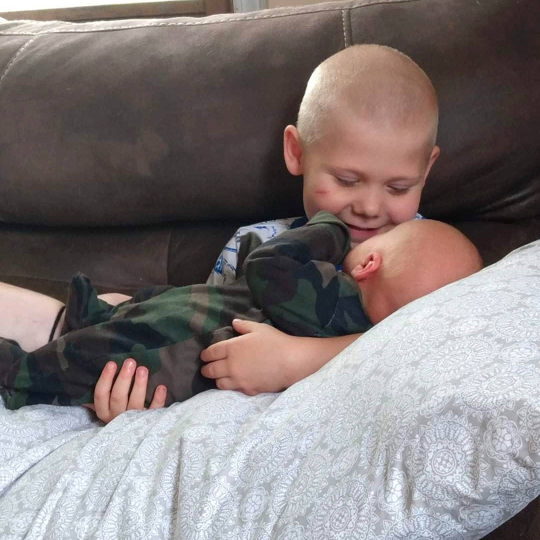 Kenneth is registered to the contest to win money with this photo: baby, baby_toddler_clothing, cheek, child, comfort, couch, elbow, eye, face, finger, human, joy, lap, linens, person, sitting, skin, smile, sofa_bed, t_shirt