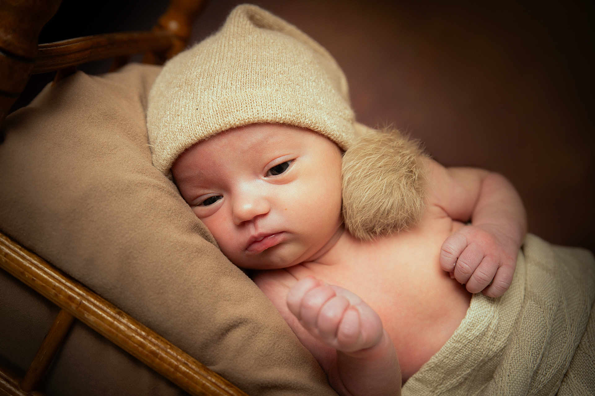 Hanaïa participe au concours pour gagner de l'argent avec cette photo : baby, newborn, infant, beanie, pompom, blanket, pillow, wicker_basket, hand, face, eyes, skin, cozy, soft_texture, portrait, close_up, neutral_colors, hat, sleepy, indoors