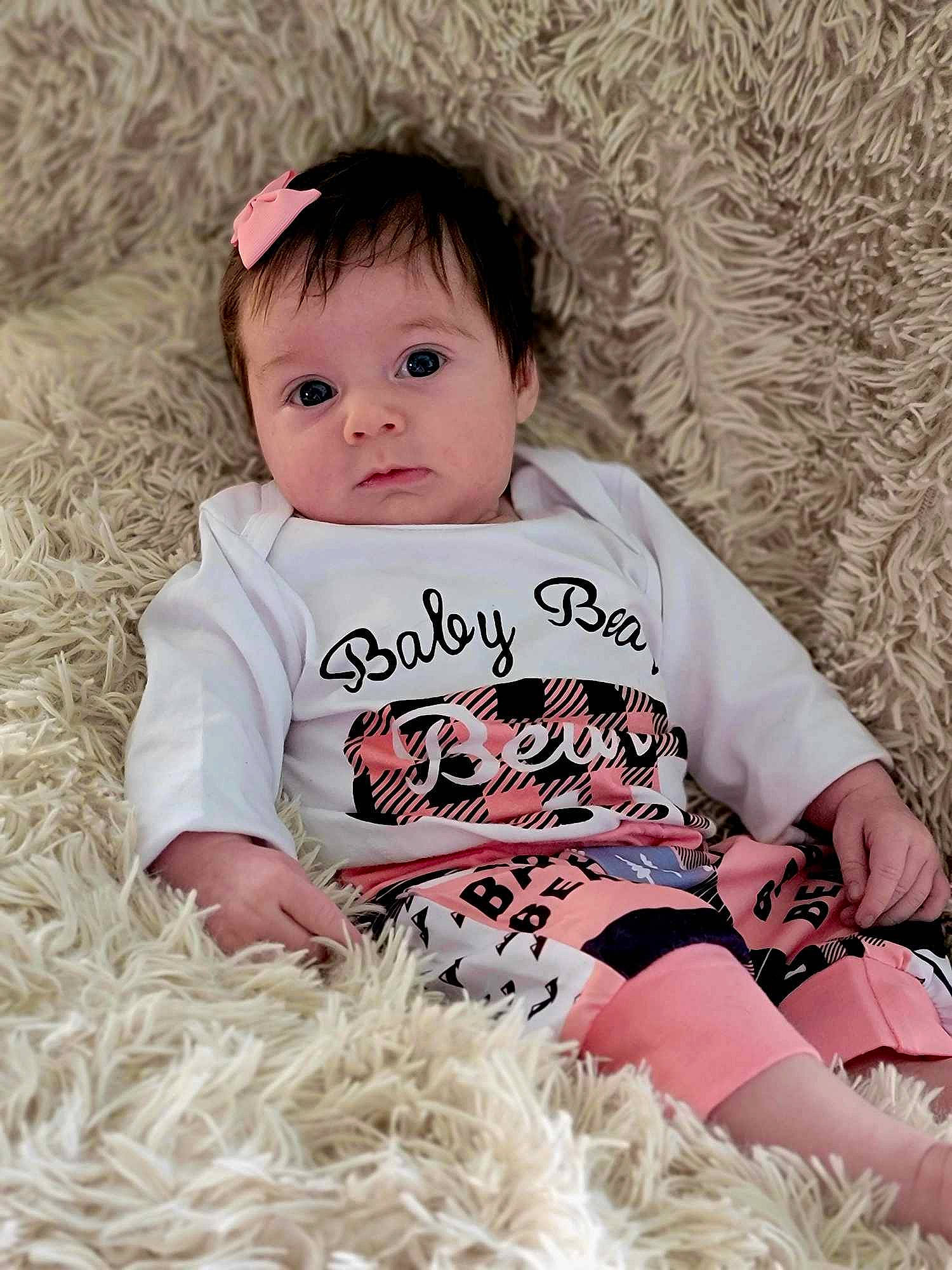 Avery is registered to the contest to win money with this photo: arm, baby, baby_toddler_clothing, cheek, child, comfort, eye, facial_expression, grass, happy, human, iris, mammal, outerwear, person, pink, skin, sleeve, textile, toddler