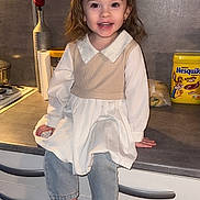 Ambre participe au concours pour gagner de l'argent avec cette photo : child, girl, smiling, barefoot, kitchen, counter, dress, vest, jeans, rose, vase, container, nesquik, food, cabinet, drawer, indoor, person, happy, portrait