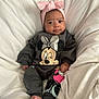 baby, infant, child, pink_bow, headband, minnie_mouse, clothing, onesie, smile, face, feet, blanket, bed, cute, indoors, portrait, person, happy, soft, resting
