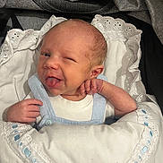 Lando is registered to the contest to win money with this photo: baby, newborn, blanket, blue_ribbon, winking, tongue_out, cute, infant, wrapped, white_clothing, smiling, face, hand, sleeping_bag, closeup, soft, indoors, portrait, child, cute_expression