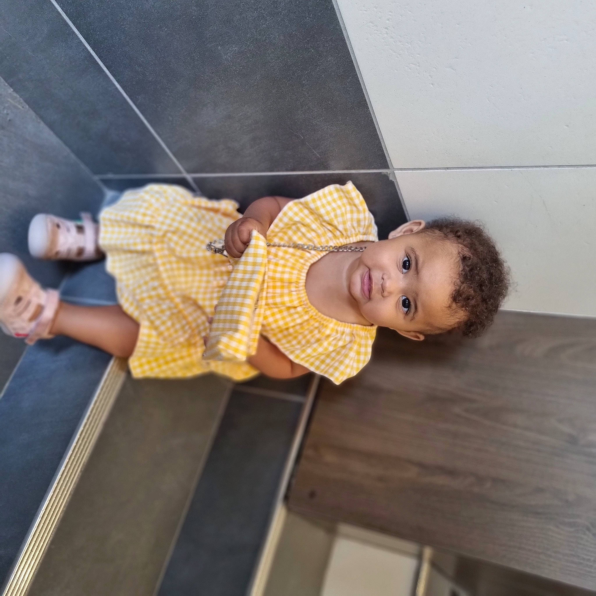 Ilianna a rejoint le concours — aidez-le/la à gagner de superbes lots ! child, floor, flooring, foot, fun, hardwood, human_leg, knee, leg, leisure, pattern, person, room, sandal, sitting, smile, thigh, toddler, waist, wood