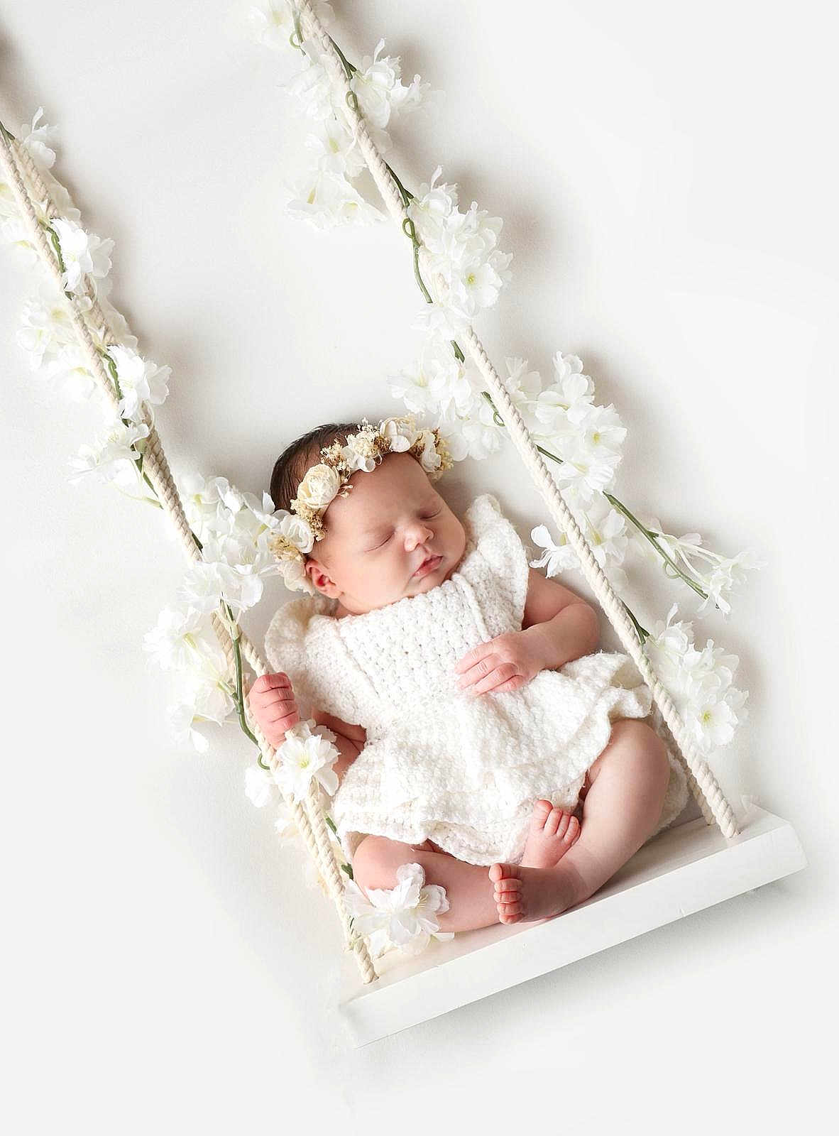 Isabella joined the competition — help win amazing prizes! baby, sleeping, white_dress, flower_crown, swing, white_flowers, infant, peaceful, soft_lighting, portrait, cute, newborn, decorative, child, resting, adorable, knitted, headband, floral, studio