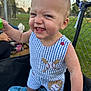 Asher is registered to the contest to win money with this photo: toddler, child, smiling, outdoor, baseball, clothing, blue_stripes, fence, grass, toy, daylight, person, happy, playful, summer, shorts, sleeveless, barefoot, field, stroller