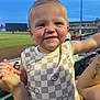baseball, checkered_shirt, child, evening, face, fun, hand_held, happy, lights, nail_polish, outdoor, person, seating, sleeveless, smiling, spectator, sports, stadium, tattoo, toddler