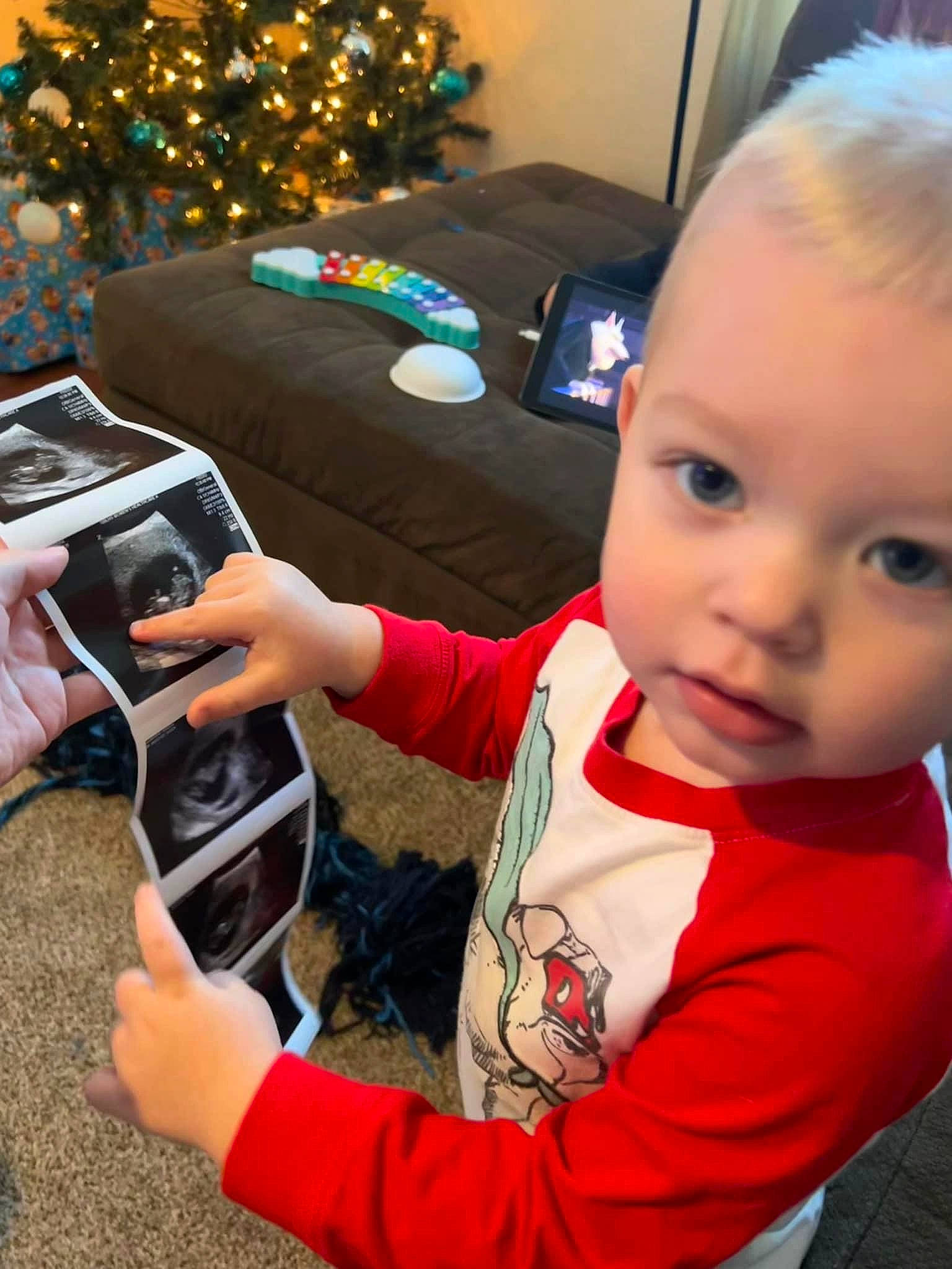 Cillian is registered to the contest to win money with this photo: baby, baby_toddler_clothing, camera, child, christmas, christmas_decoration, christmas_eve, christmas_ornament, christmas_tree, electronic_device, event, gadget, holiday, holiday_ornament, person, single_lens_reflex_camera, sitting, t_shirt, toddler, tree