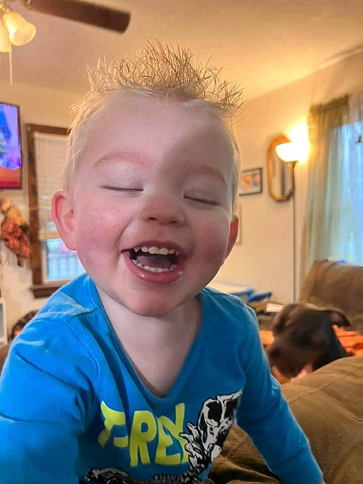 Cillian is registered to the contest to win money with this photo: baby, cheek, child, couch, curtain, ear, eyebrow, forehead, fun, happy, jaw, mouth, neck, nose, person, picture_frame, sitting, smile, t_shirt, toddler