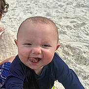 Wyatt is registered to the contest to win money with this photo: baby, child, beach, sand, ocean, water, play, smile, tongue, navy_shirt, shorts, sunny, outdoor, summer, fun, happy, cute, person, nature, vacation