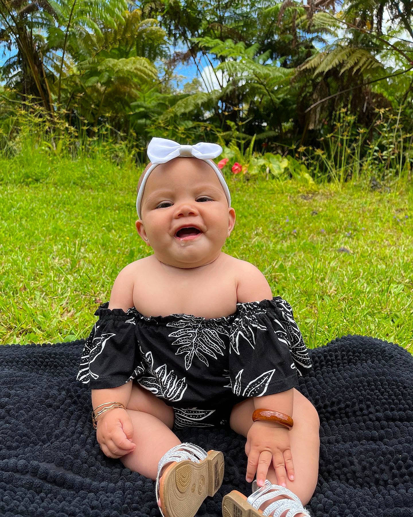Tyslen Key is registered to the contest to win money with this photo: baby, baby_toddler_clothing, child, event, fun, grass, happy, hat, lap, leisure, pattern, people_in_nature, person, plant, sitting, sky, summer, sun_hat, thigh, toddler