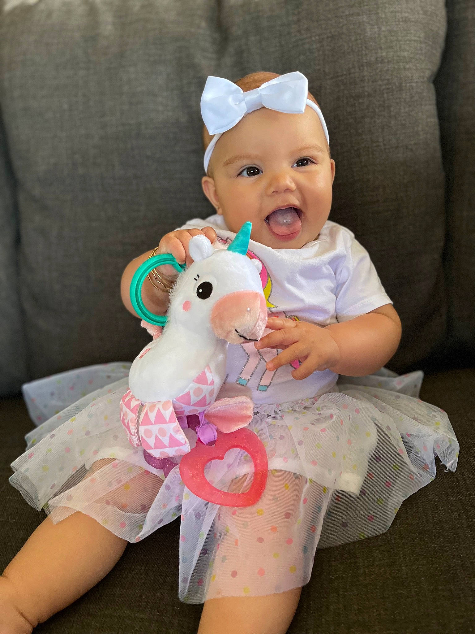 Tyslen Key is registered to the contest to win money with this photo: baby, baby_toddler_clothing, comfort, costume_hat, couch, dress, eye, fun, happy, hat, head, headwear, human_body, person, pink, skin, sleeve, smile, stuffed_toy, toddler
