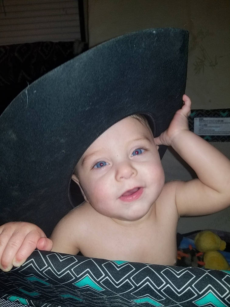 Wrangler is registered to the contest to win money with this photo: baby, cap, cheek, child, costume_accessory, costume_hat, ear, eye, face, fashion_accessory, fun, hand, hat, head, headgear, person, skin, smile, sun_hat, toddler