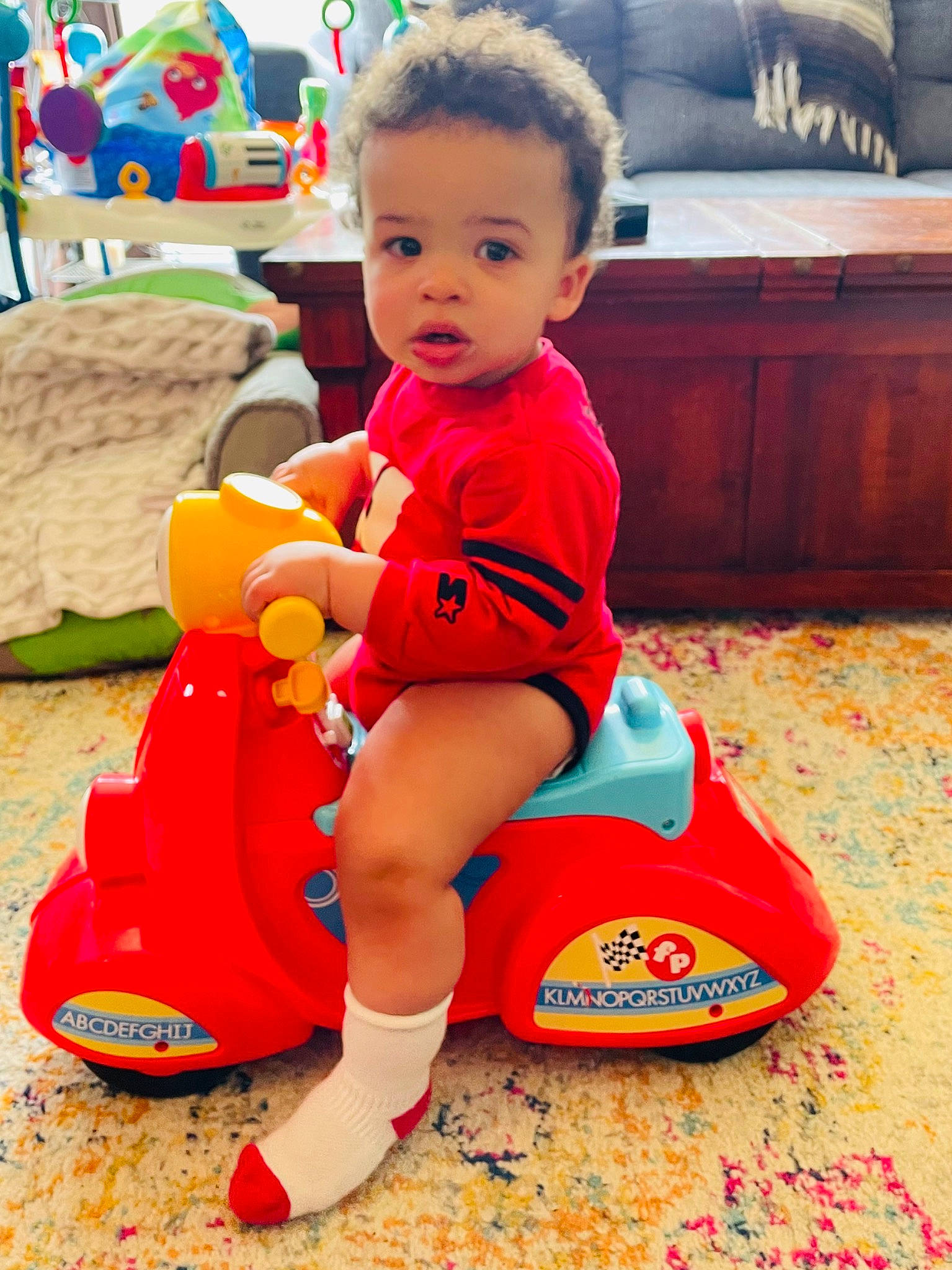 Desmond joined the competition — help win amazing prizes! baby, baby_playing_with_toys, baby_toddler_clothing, child, couch, fun, happy, head, human_leg, leisure, person, play, recreation, riding_toy, shoe, sneakers, thigh, tire, toddler, toy