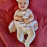 Aïline a rejoint le concours — aidez-le/la à gagner de superbes lots ! baby, smiling, headband, bow, dress, tights, blanket, infant, happy, cute, child, laying, clothing, person, indoors, portrait, skin, head, face, young