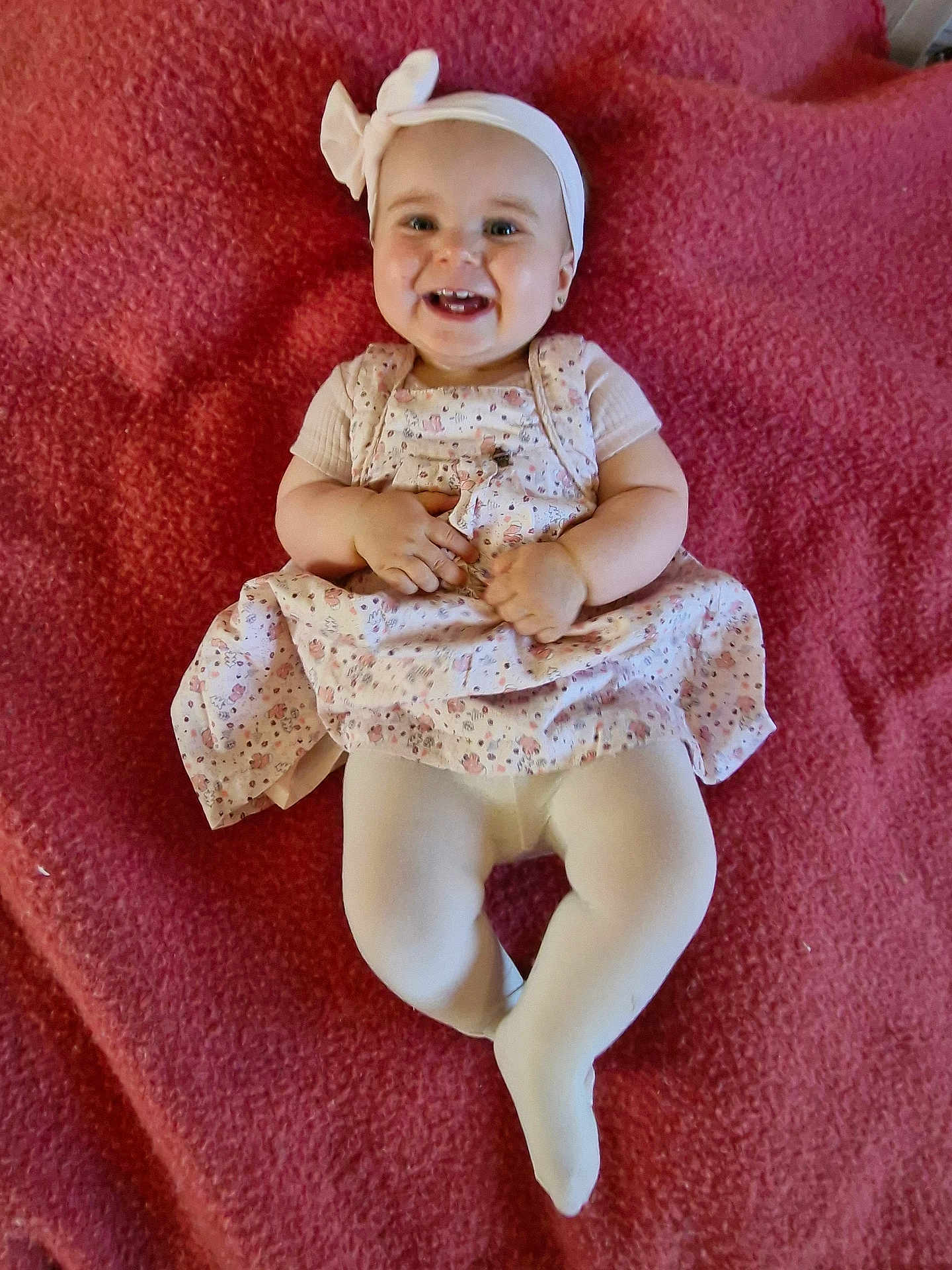 Aïline a rejoint le concours — aidez-le/la à gagner de superbes lots ! baby, smiling, headband, bow, dress, tights, blanket, infant, happy, cute, child, laying, clothing, person, indoors, portrait, skin, head, face, young