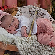 Lylia a rejoint le concours — aidez-le/la à gagner de superbes lots ! baby, sleeping, pink_clothing, white_shirt, headband, bow, blanket, knitted_blanket, wooden_chair, parasol, lace_parasol, floral_background, indoors, cozy, peaceful, infant, soft_lighting, portrait, cute, resting
