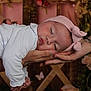 baby, sleeping, headband, hands, tattoo, bracelet, white_clothing, face, infant, peaceful, portrait, pink, flower, butterfly, background, soft_lighting, closeup, child, human, resting