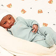 Karol a rejoint le concours — aidez-le/la à gagner de superbes lots ! baby, newborn, infant, blanket, onesie, hat, teddy_bear_pattern, quilt, soft_texture, cozy, resting, cute, sleepwear, child, portrait, indoors, comfort, peaceful, small_hands, lying_down