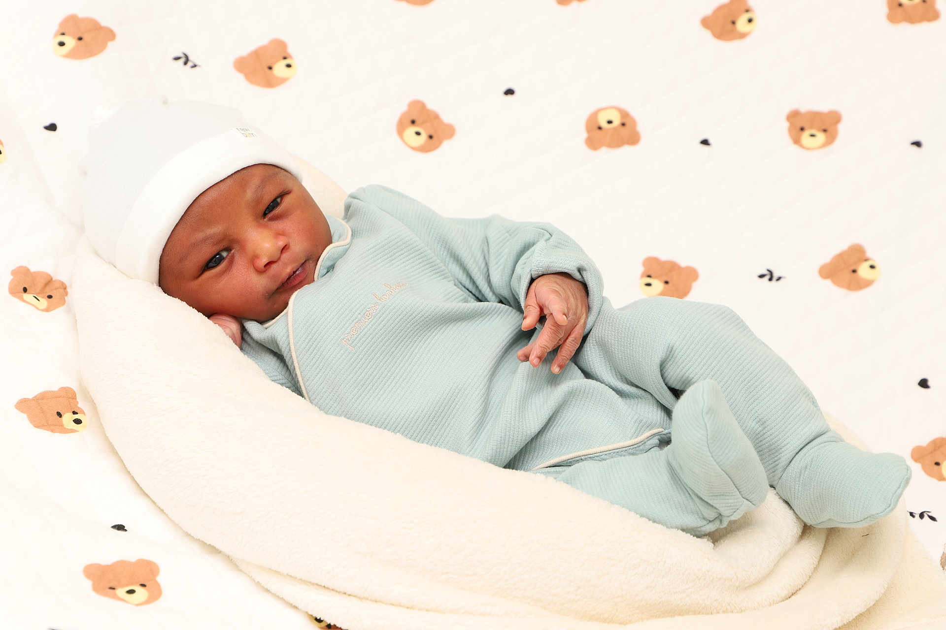 Karol a rejoint le concours — aidez-le/la à gagner de superbes lots ! baby, newborn, infant, blanket, onesie, hat, teddy_bear_pattern, quilt, soft_texture, cozy, resting, cute, sleepwear, child, portrait, indoors, comfort, peaceful, small_hands, lying_down