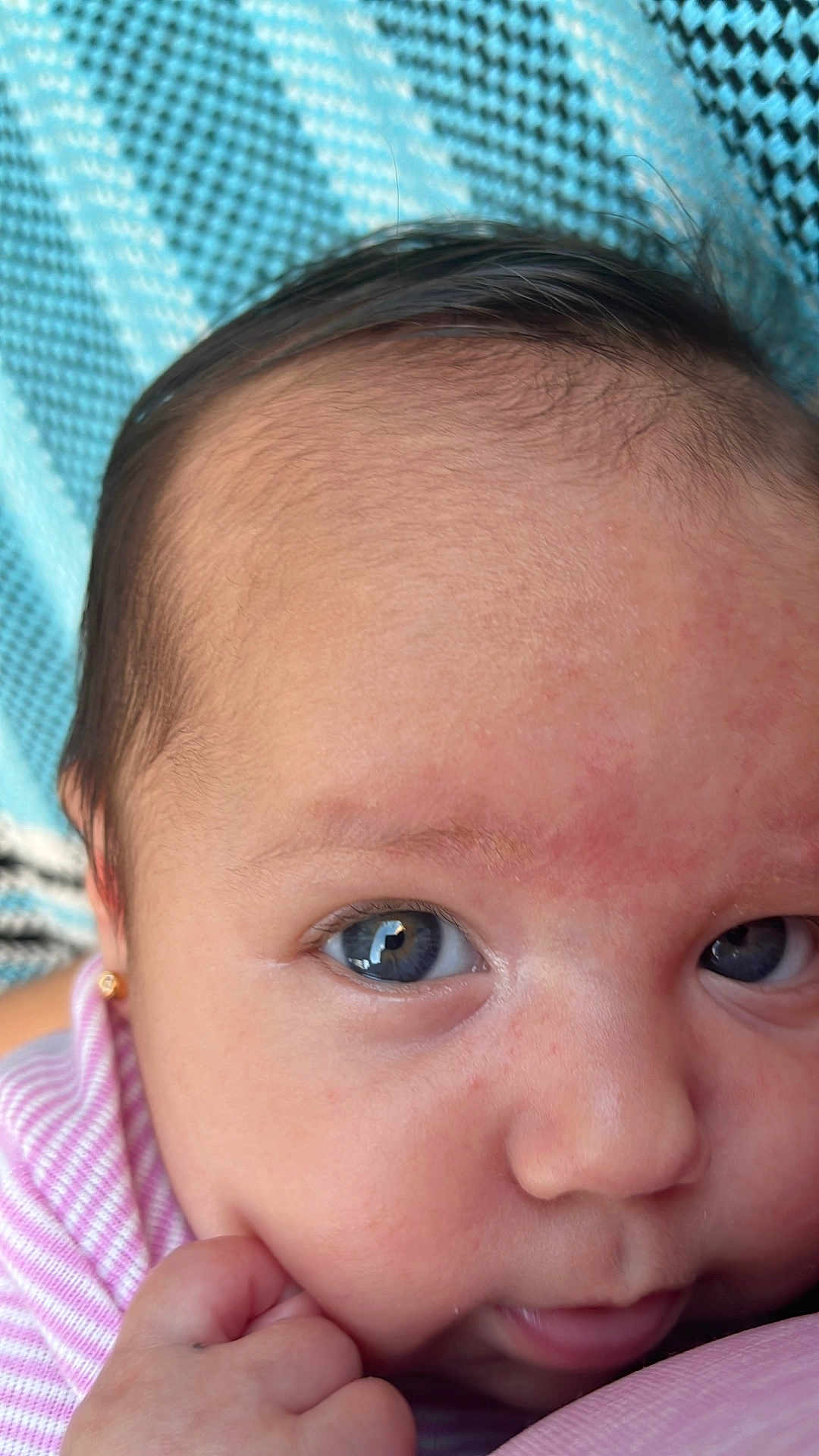 Isabella joined the competition — help win amazing prizes! baby, close_up, blue_eyes, hand, pink_stripes, face, infant, skin, portrait, cute, child, young, resting, expression, human, person, eyelashes, nose, mouth, earring