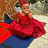 baby, child, red_dress, headband, gingerbread_man, christmas_tree, holiday, decoration, floor, sitting, cute, festive, indoor, portrait, person, holiday_season, sparkle, toy, event, happy