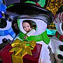 child, christmas_lights, colorful, decoration, face, festive, gift_box, green, happy, hat, holiday, holiday_decoration, indoor, person, red, smiling, snowman, toy, white, winter