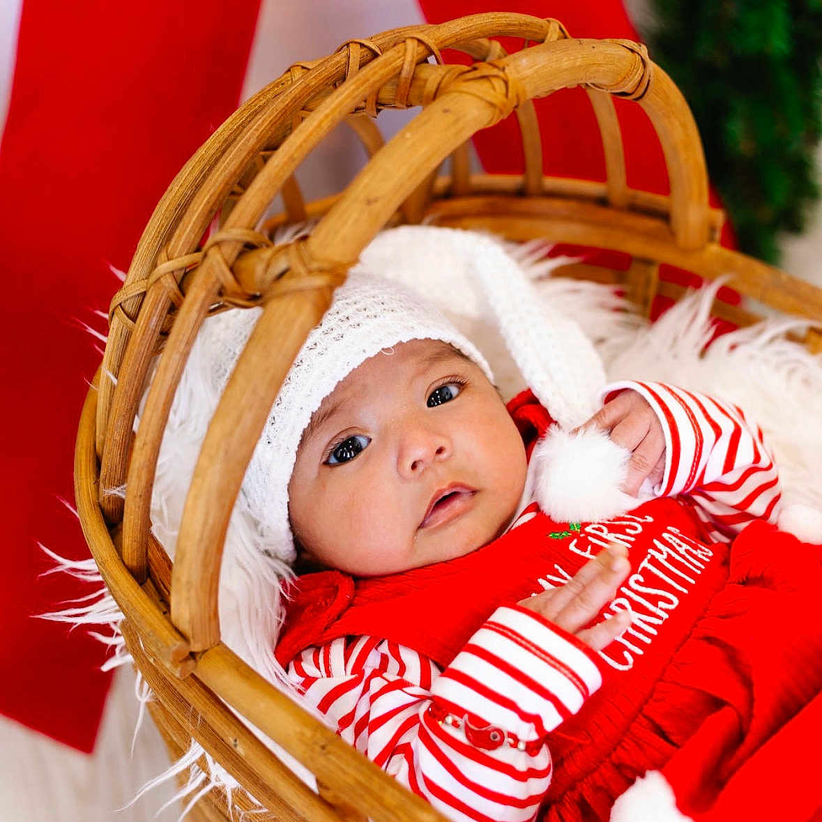 Emirett joined the competition — help win amazing prizes! baby, basket, child, christmas, cozy, cute, decor, festive, fur_blanket, holiday, indoors, infant, newborn, pom_pom, portrait, red_clothing, smiling, striped_sleeves, white_hat, wooden_basket