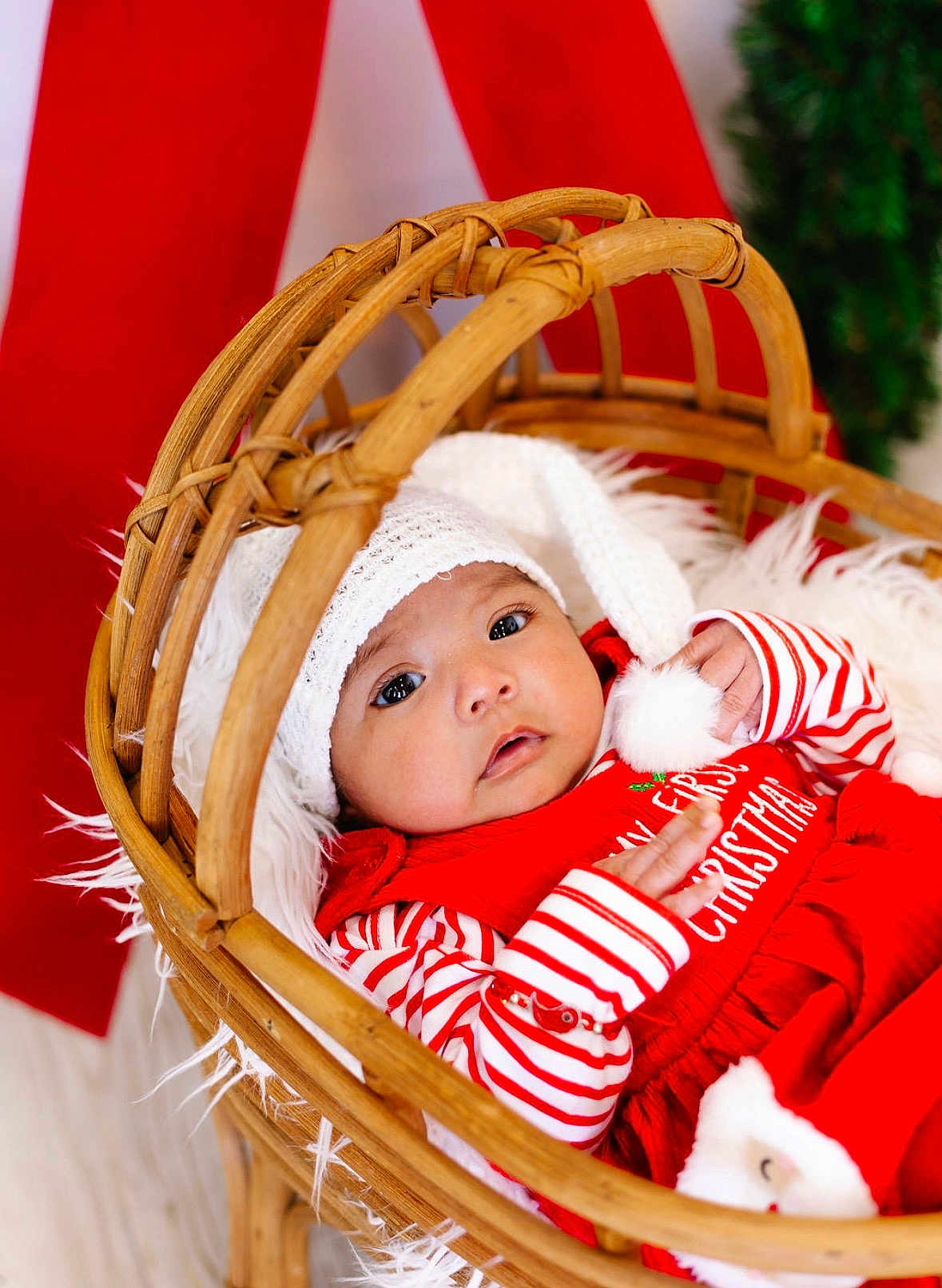 Emirett joined the competition — help win amazing prizes! baby, infant, basket, red_clothing, white_hat, striped_sleeves, pom_pom, fur_blanket, holiday, christmas, festive, cute, portrait, indoors, wooden_basket, newborn, cozy, decor, child, smiling