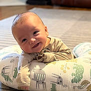 Tatum is registered to the contest to win money with this photo: baby, infant, smile, pillow, animal_print, cute, indoors, happy, child, toddler, face, expression, clothing, soft_lighting, floor, carpet, home, portrait, baby_girl, baby_boy
