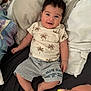 Alejandro participe au concours pour gagner de l'argent avec cette photo : baby, child, smiling, bed, pillow, clothing, shorts, shirt, palm_tree_print, happy, feet, hand, indoors, person, infant, cute, relaxed, portrait, lying_down, skin