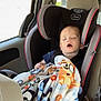 toddler, child, car_seat, blanket, sleeping, car_interior, seatbelt, window, sunlight, nap, child_safety, clothing, red_blanket, car, seat, headrest, interior, comfort, young_child, relaxation