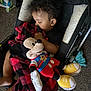Brashaun is registered to the contest to win money with this photo: toddler, sleeping, stroller, blanket, plush_toy, mickey_mouse, carpet, indoor, child, pacifier, curly_hair, clothing, foot, relaxation, comfort, baby, toy, nap, cute, peaceful