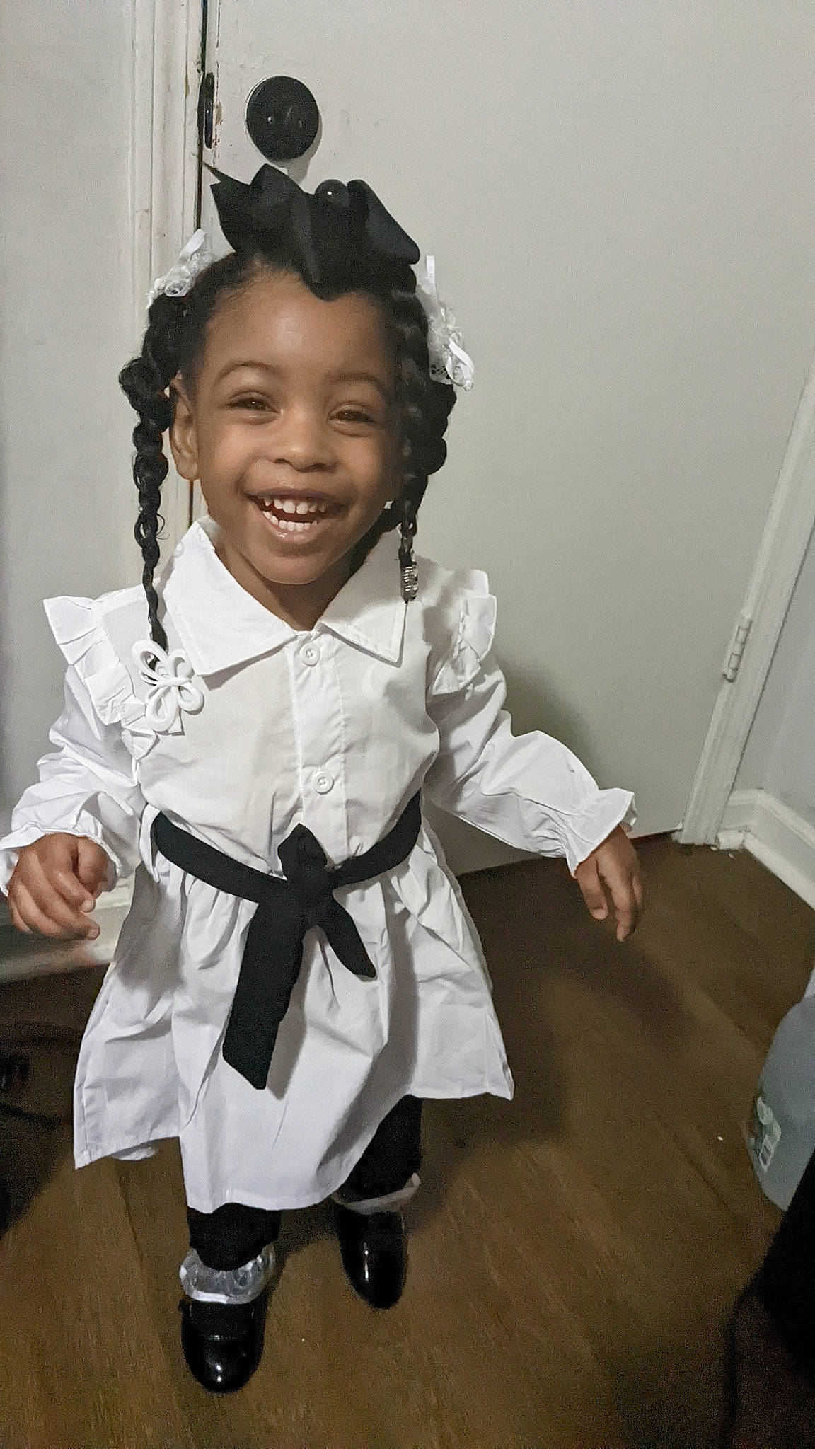 Lovely is registered to the contest to win money with this photo: baby_toddler_clothing, child, fashion_accessory, fashion_design, formal_wear, gesture, hair_tie, hairstyle, happy, jewellery, joy, outerwear, pattern, person, room, school_uniform, sleeve, smile, sock, standing