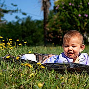 Octavia a rejoint le concours — aidez-le/la à gagner de superbes lots ! baby, blanket, child, cute, daylight, flower_bouquet, grass, greenery, happy, infant, nature, outdoor, playful, portrait, purple_flowers, relaxing, smiling, sunny, wildflowers, yellow_flowers