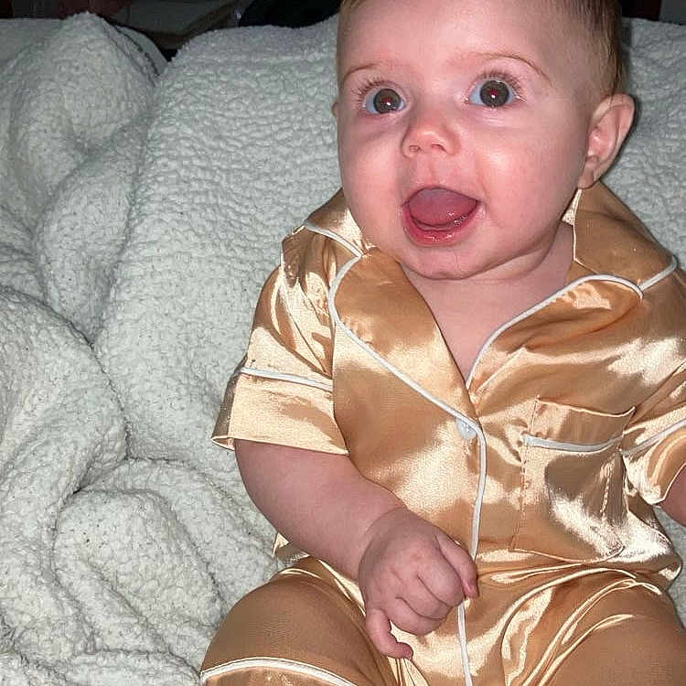 Layla joined the competition — help win amazing prizes! baby, bed, bedroom, clothing, couch, dress, face, furniture, happy, head, homedecor, indoors, pajamas, person, photography, portrait, quilt, room, shorts, sitting