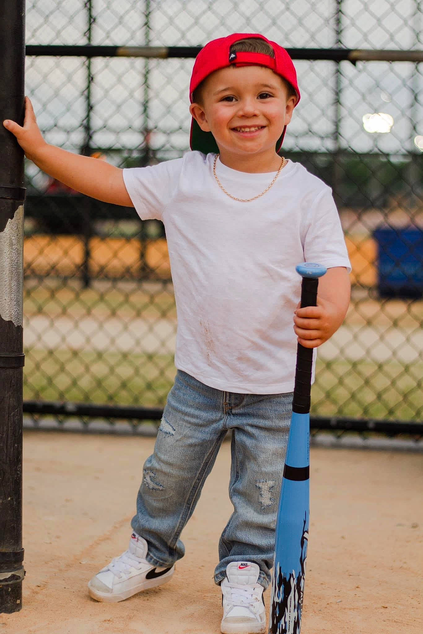 Keaston joined the competition — help win amazing prizes! arm, baseball_cap, baseball_equipment, baseball_player, cap, fence, fun, happy, headwear, helmet, joy, mammal, person, player, shorts, smile, sneakers, sports_equipment, sports_gear, standing